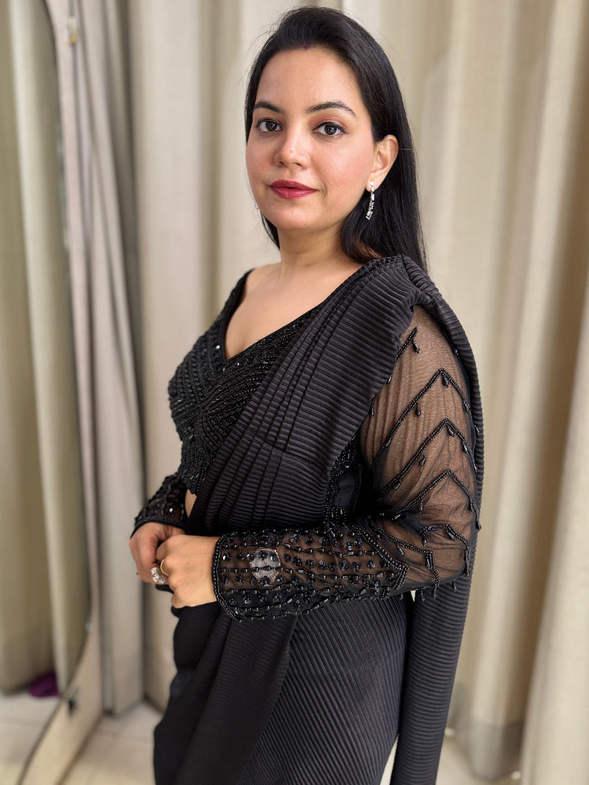 Black drape saree with heavy hand embroidered net blouse and imported pleated fabric of saree.
