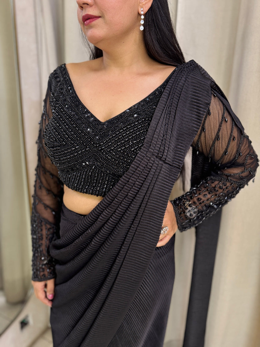 Black drape saree with heavy hand embroidered net blouse and imported pleated fabric of saree.