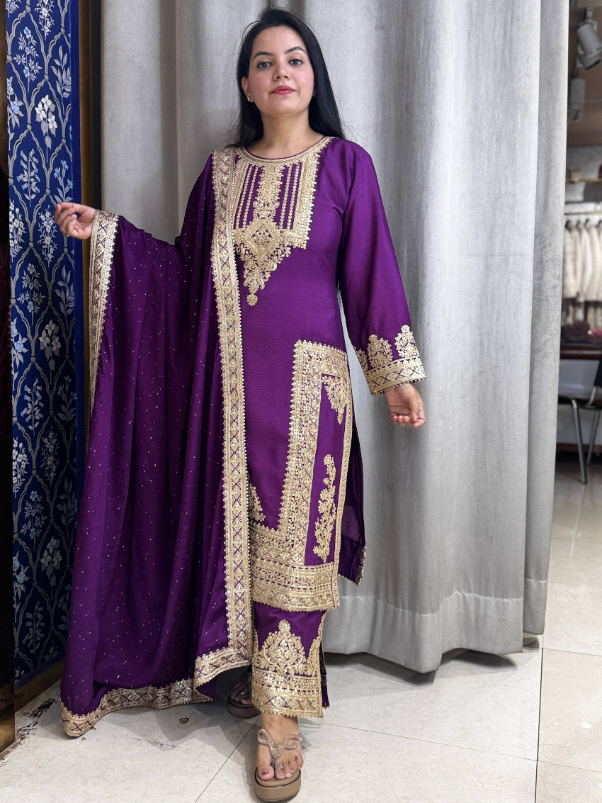 Woman wearing a purple traditional outfit with gold embroidery in a store setting.