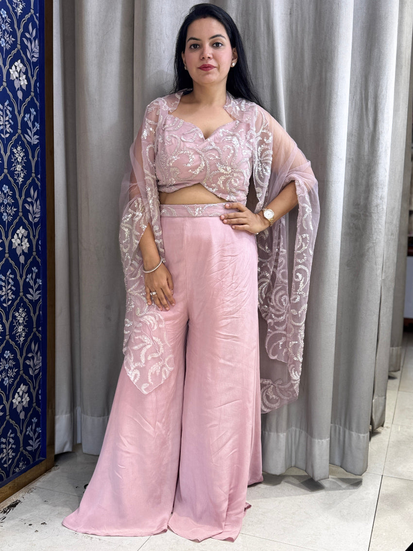Woman wearing a pink traditional outfit with a matching dupatta in a room.