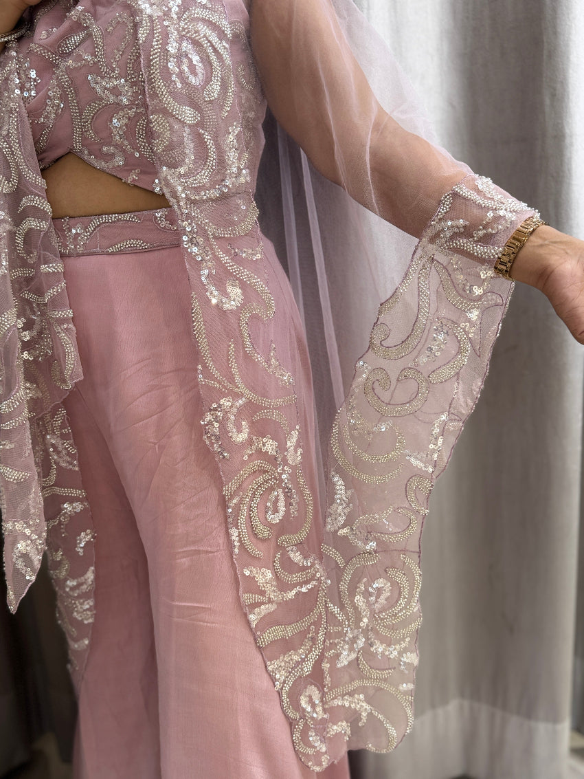 Pink outfit with intricate white lace detailing on a neutral background