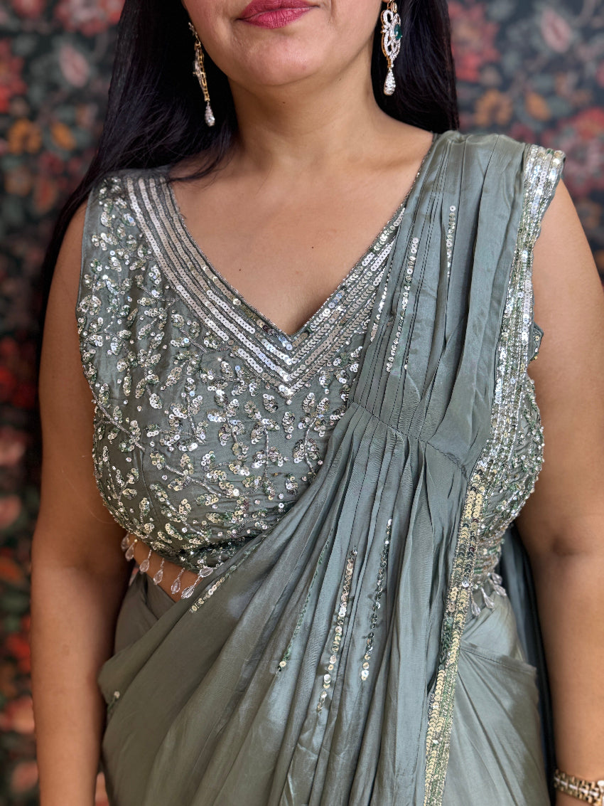 Woman wearing a silver saree with a textured background