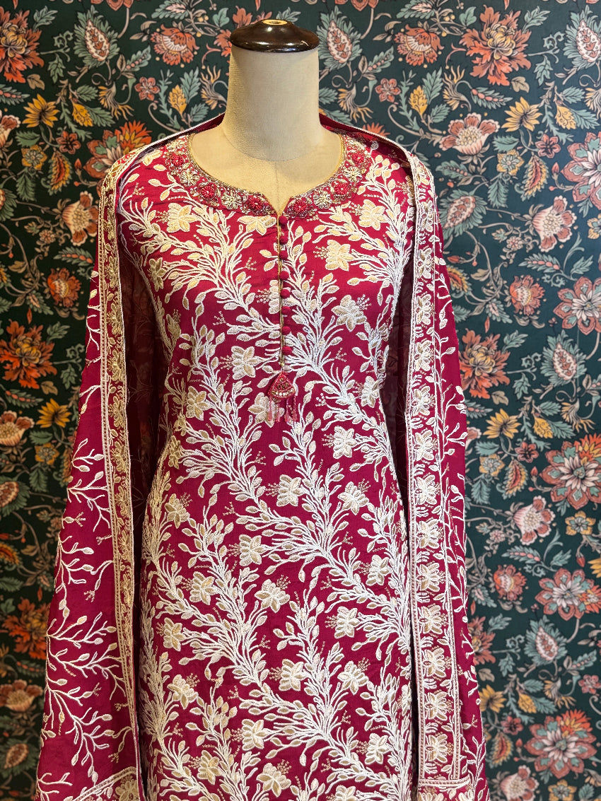 Red and white floral patterned dress on a mannequin against a floral background