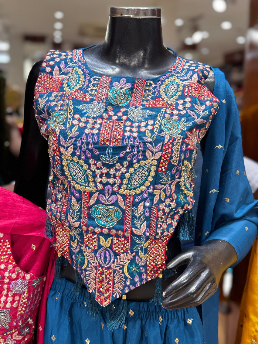Mannequin wearing a colorful embroidered vest with a blurred indoor background