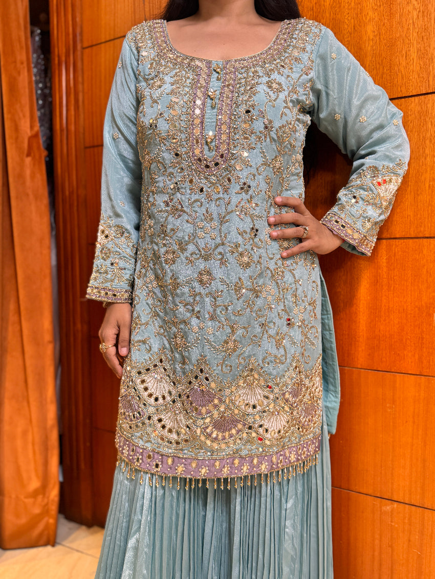 Light blue embroidered traditional outfit against a wooden background