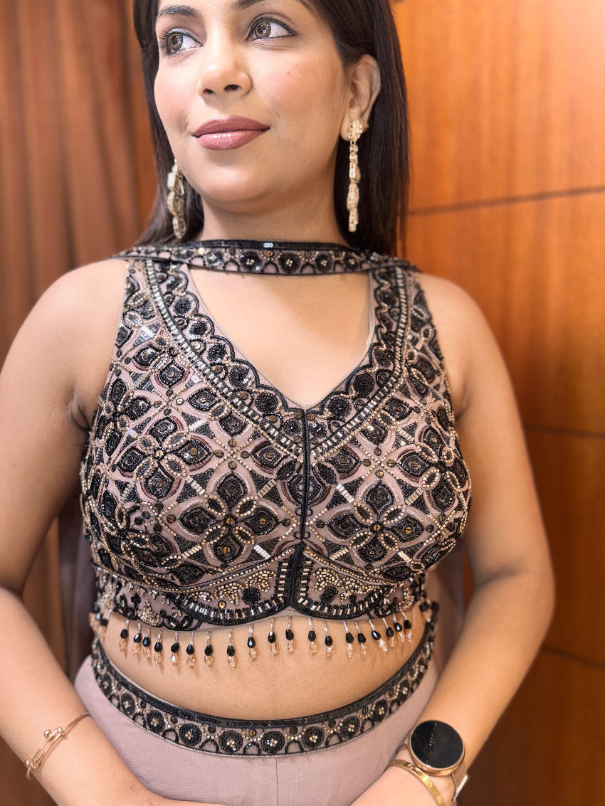 Woman wearing a black and gold embroidered top with a blurred background