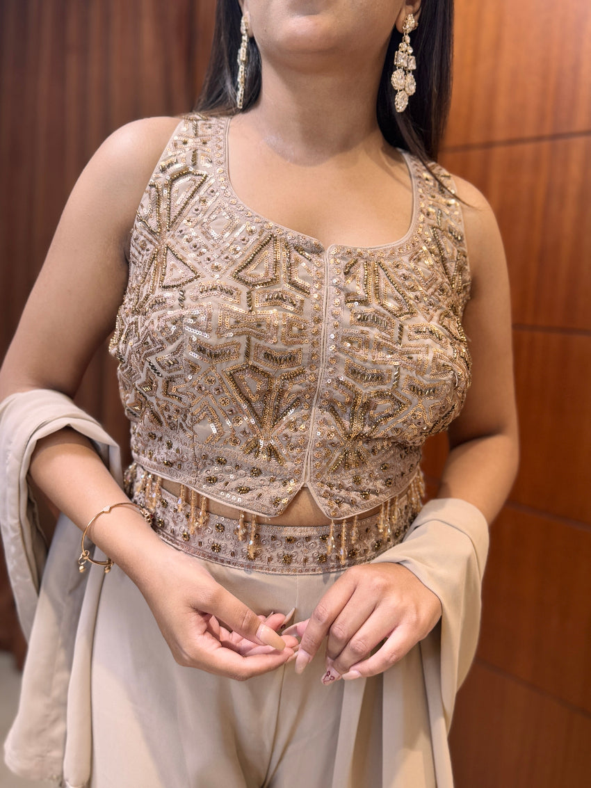 Woman wearing a beaded top with a neutral background