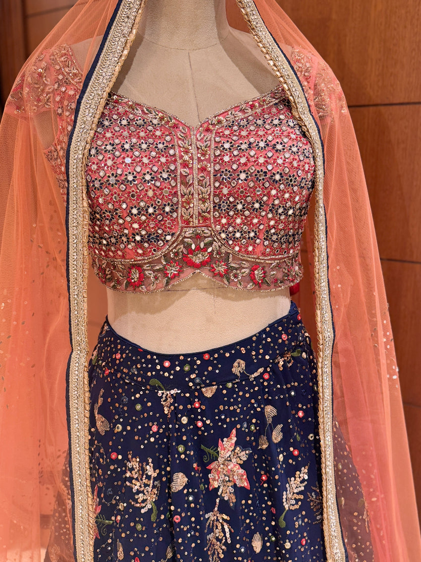 Traditional outfit with floral blouse and navy skirt on a mannequin against a wooden background