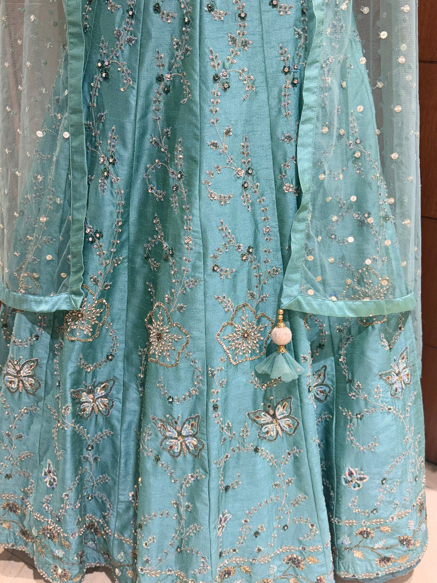 Light blue embroidered fabric with floral patterns and beads.