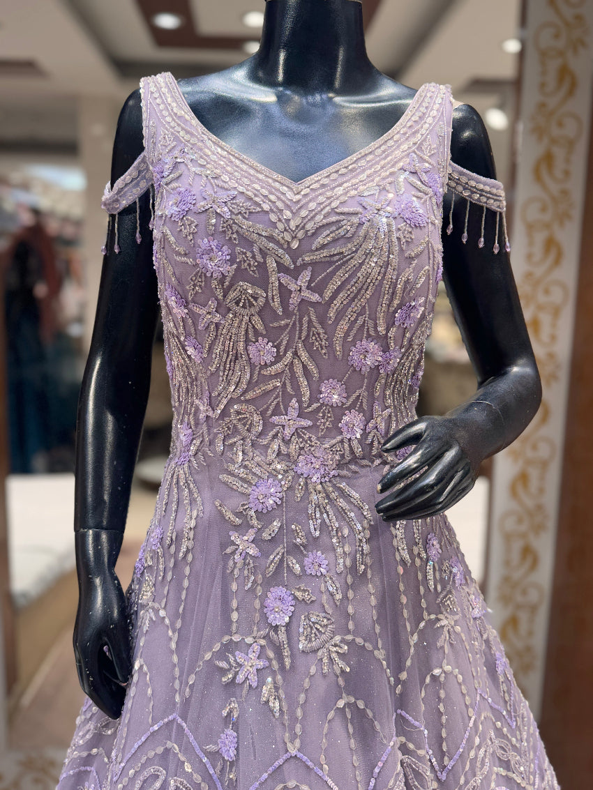 Lavender evening gown with intricate beadwork on a mannequin in an indoor setting.