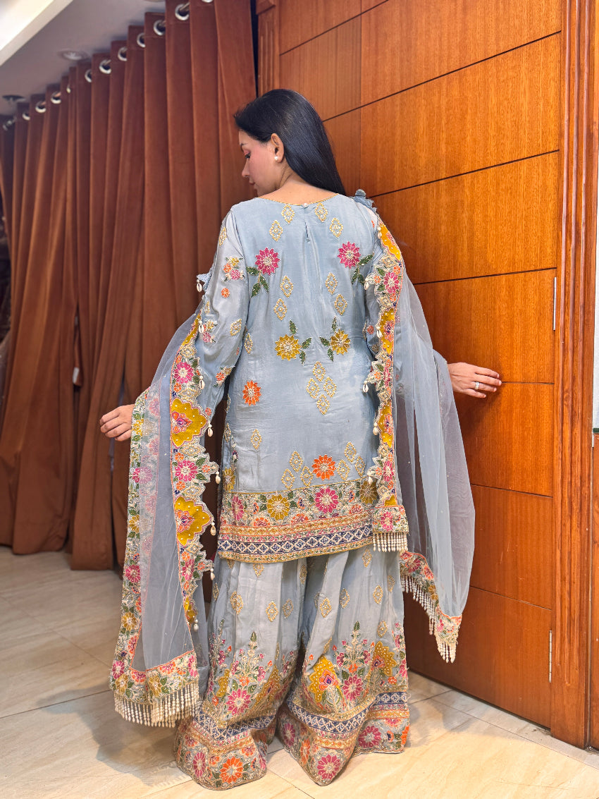 Powder blue hand embroidered designer sharara suit with multi colored cut work dupatta