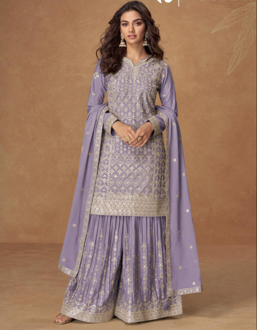 Woman wearing a traditional outfit with a purple dupatta on a brown background