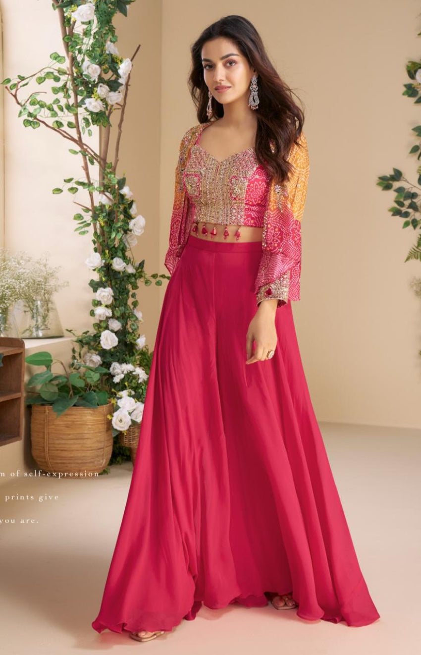 Woman wearing a pink traditional outfit with gold accents in a decorated indoor setting.