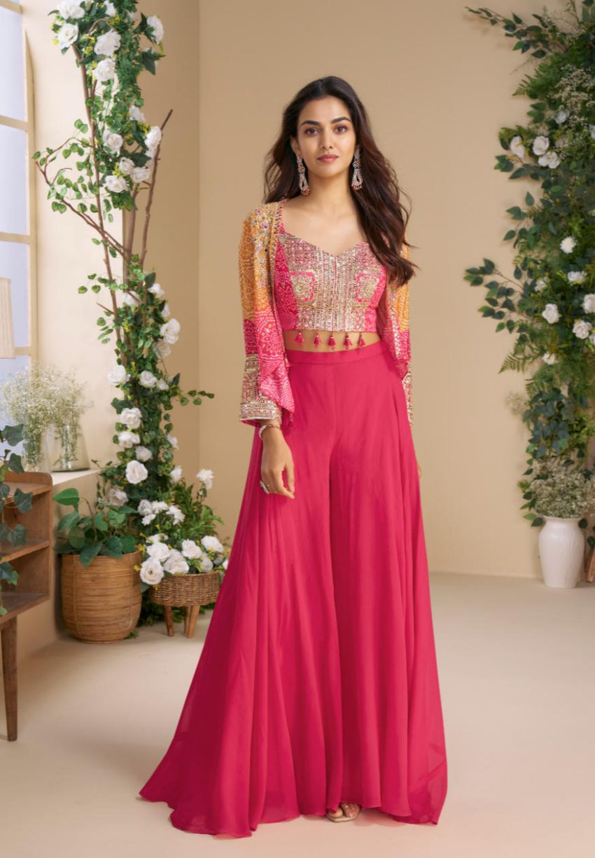 Woman in a pink traditional outfit with floral decorations indoors.