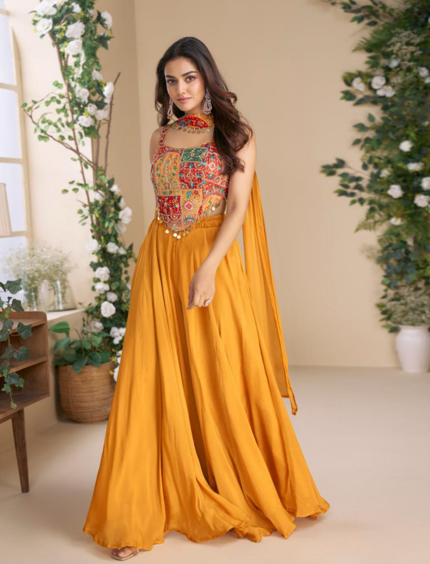 Woman wearing a colorful top and mustard yellow skirt in a decorated room.