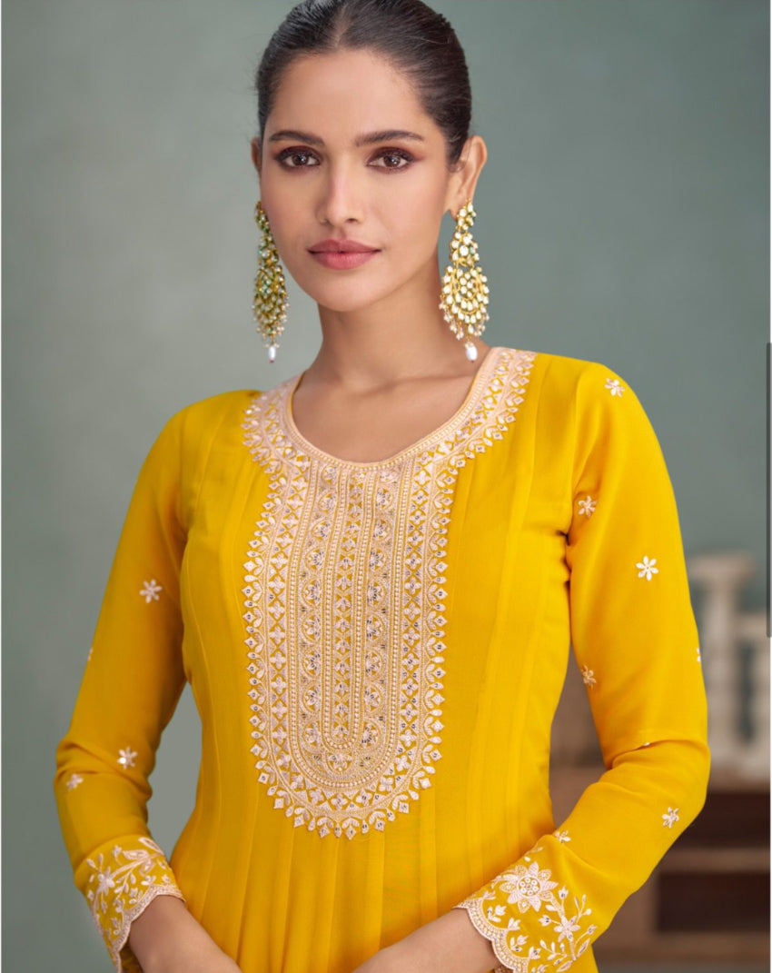 Woman wearing a yellow embroidered outfit with a gray background
