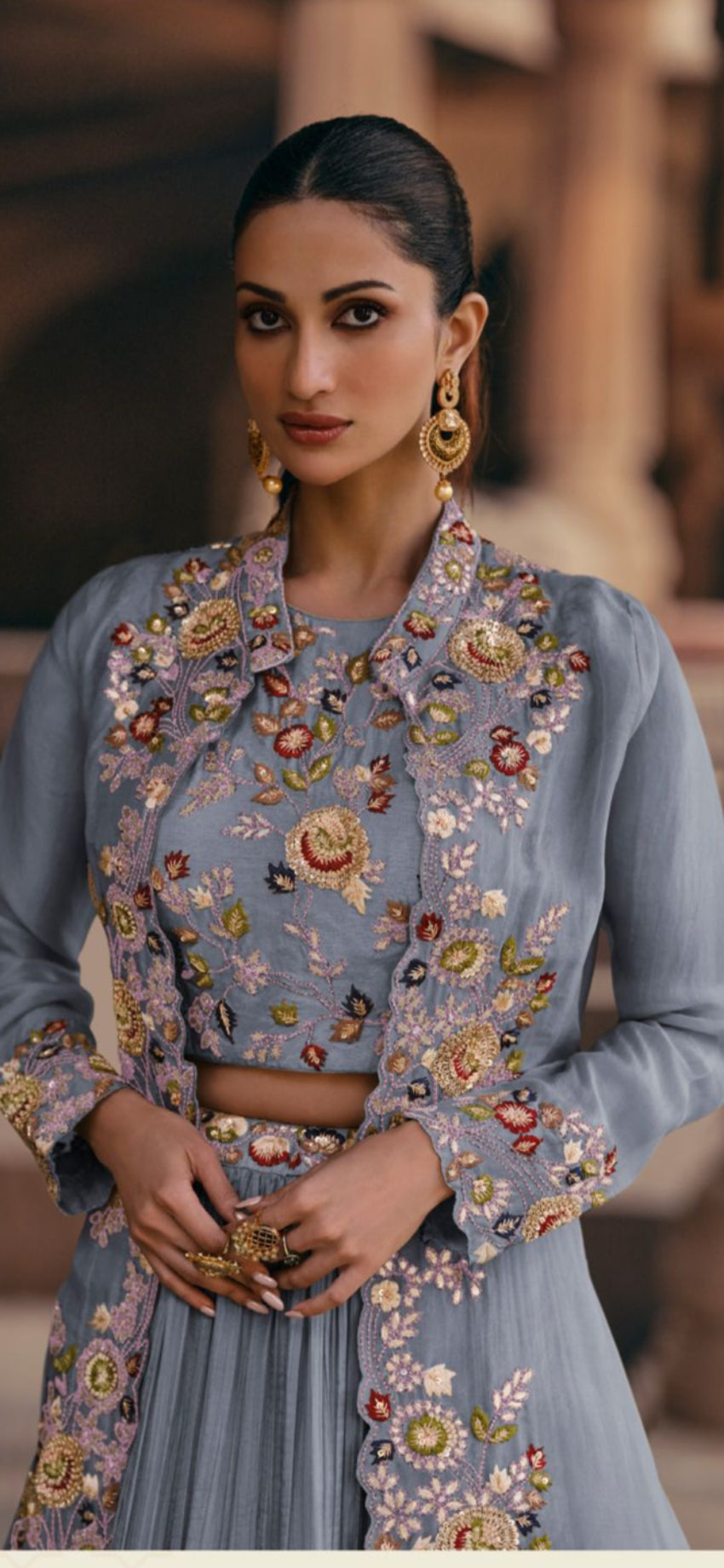 Woman wearing a light blue embroidered outfit with a blurred background