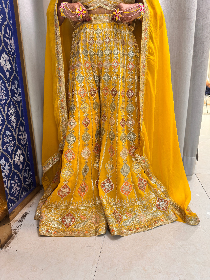 Yellow saree with intricate patterns draped over a chair