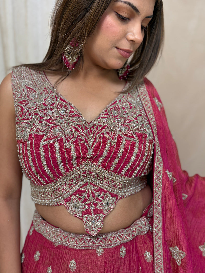 Woman wearing a pink and silver embroidered traditional outfit.