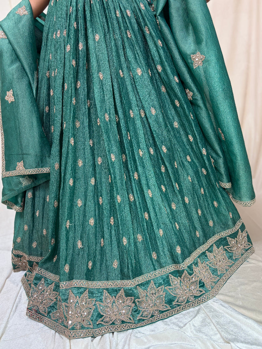 Green traditional outfit with intricate patterns on a light background