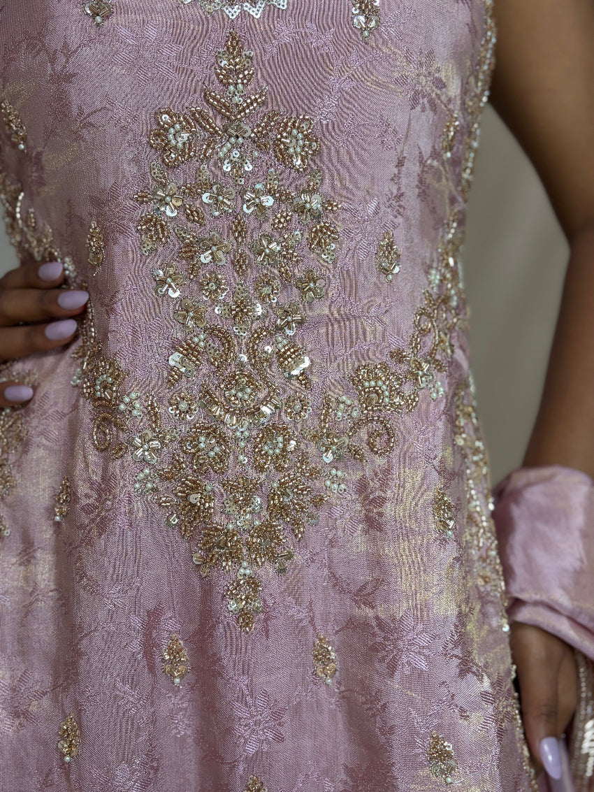 Close-up of a pink dress with gold embroidery and sequins.