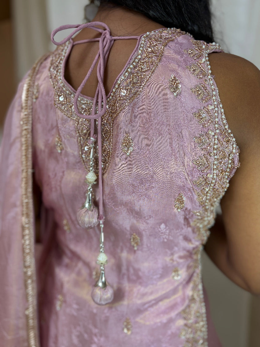 Pink embroidered dress with intricate detailing and a decorative necklace.