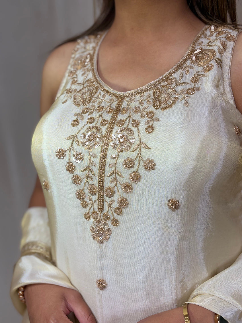 White sleeveless top with gold embroidery on a plain background
