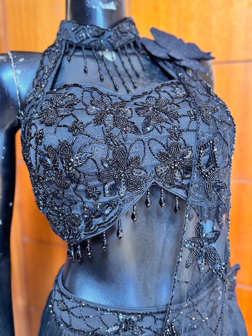 Black embroidered lace top on a mannequin against a wooden background