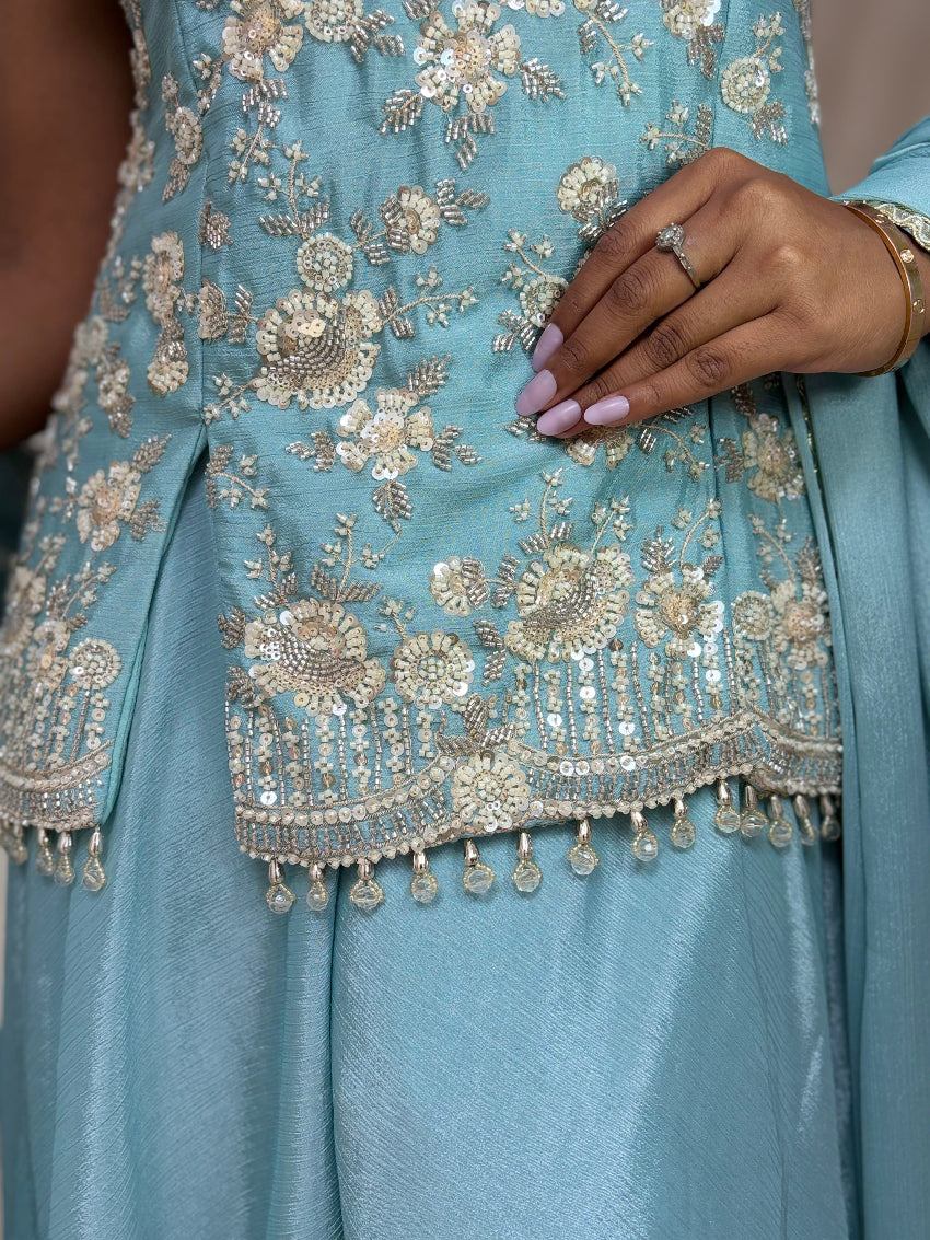 Light blue dress with intricate gold embroidery and embellishments.