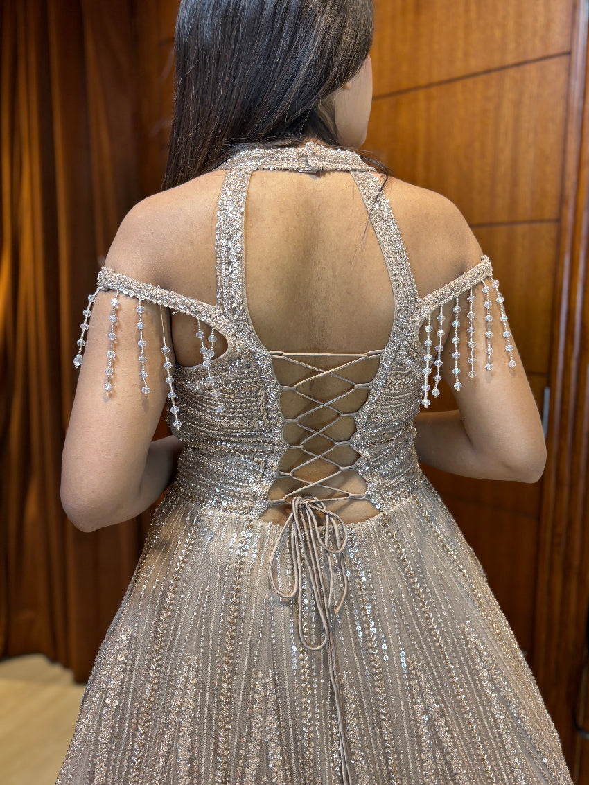 Back view of a person wearing a sparkling silver dress with intricate detailing.