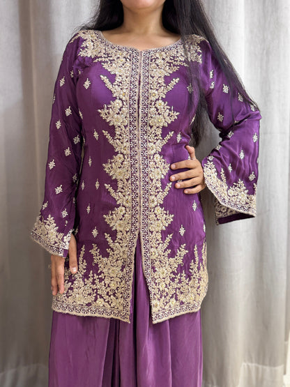 Purple traditional outfit with gold embroidery on a plain background