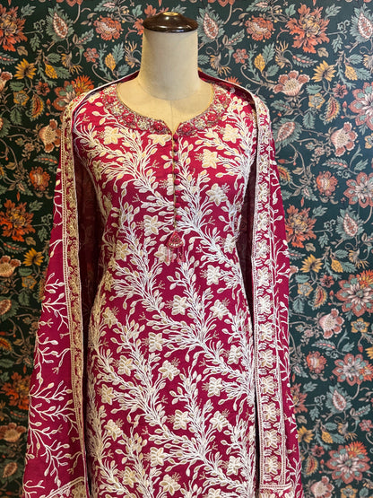 Red and white floral patterned dress on a mannequin against a floral background