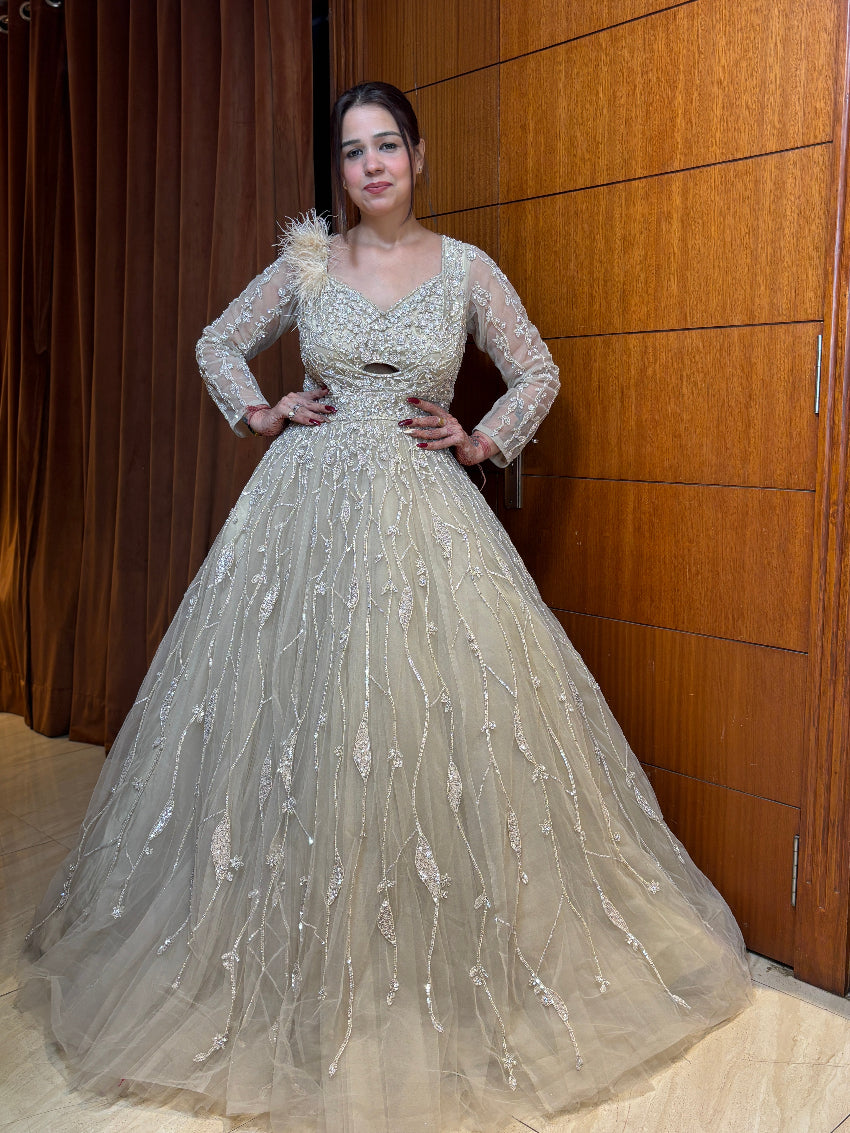 Woman in an elegant white gown standing against a wooden panel background
