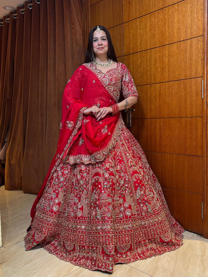 Woman in a red and gold traditional outfit standing against a wooden panel background