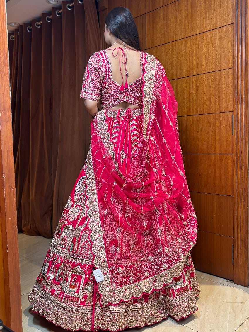 Person wearing a red and gold embroidered traditional outfit in a room with wooden doors.