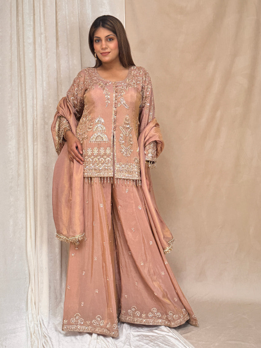 Woman wearing a traditional embroidered outfit against a neutral background