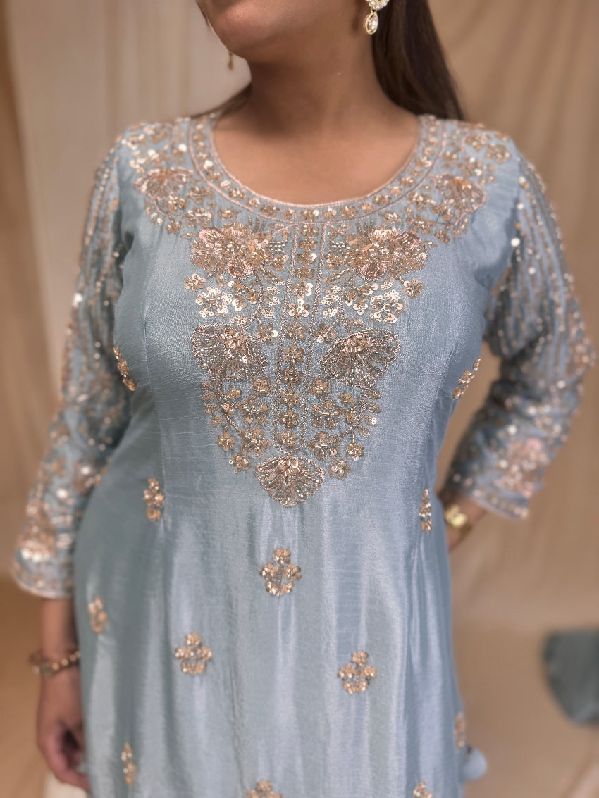 Light blue dress with gold embroidery on a neutral background