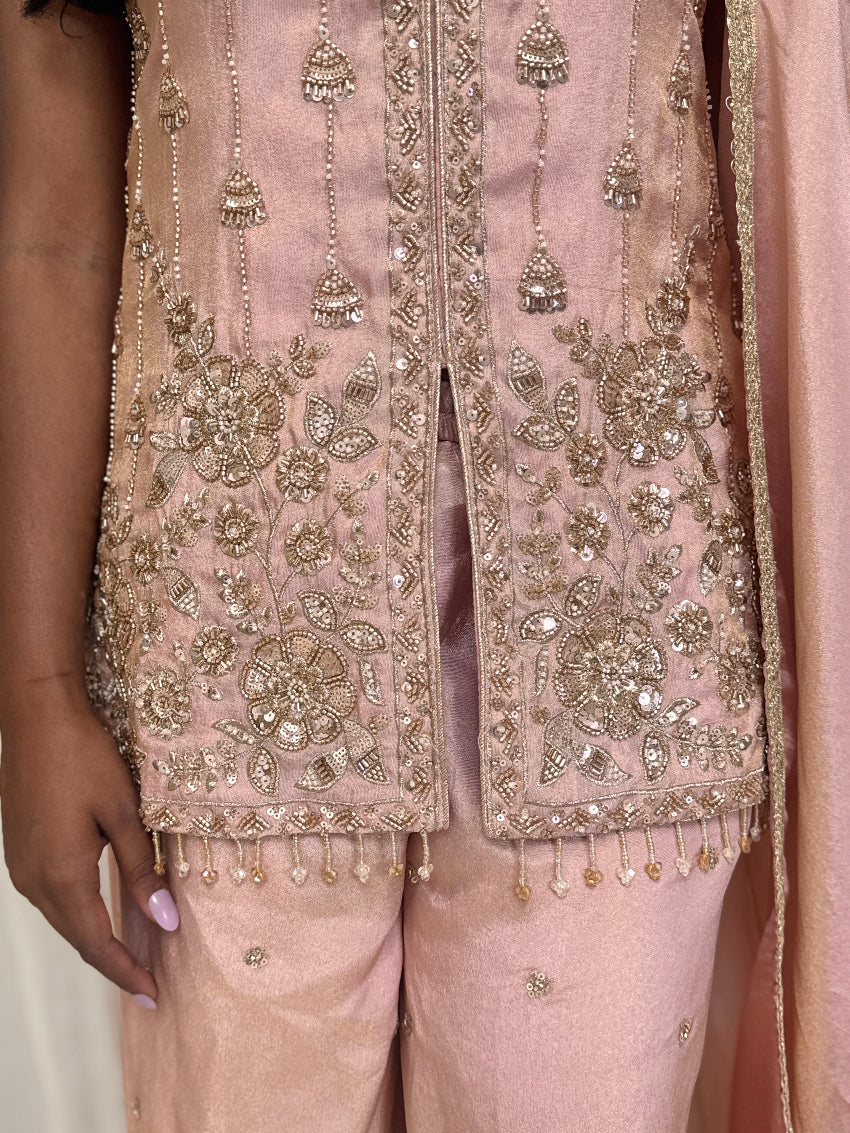 Pink embroidered traditional outfit with intricate designs and embellishments.