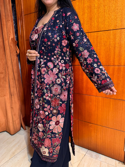 Person wearing a floral patterned dress against a wooden background