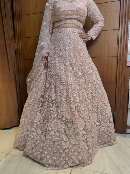 Beige embroidered traditional outfit with a long skirt and top on a wooden floor.