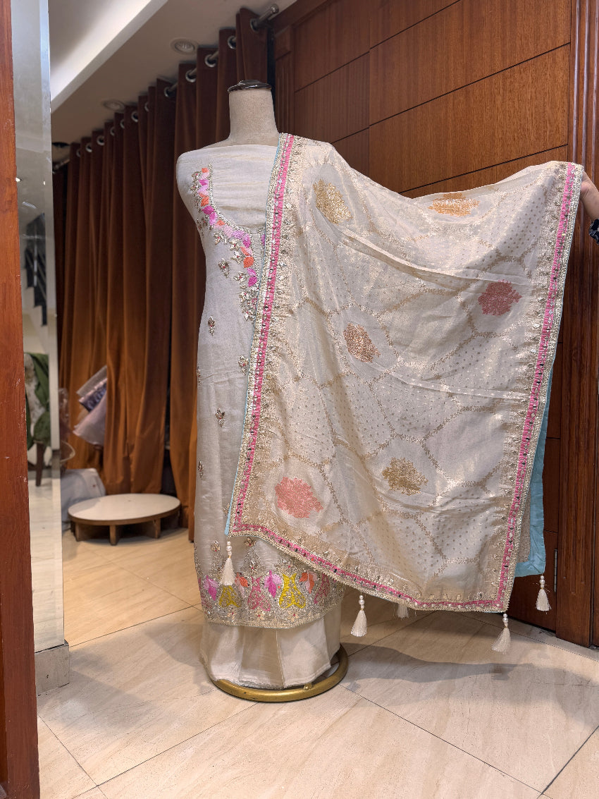 Mannequin wearing a traditional embroidered saree with a wooden panel background