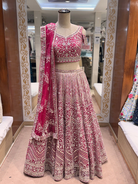 Pink and white patterned lehenga with dupatta on a mannequin in a store setting.
