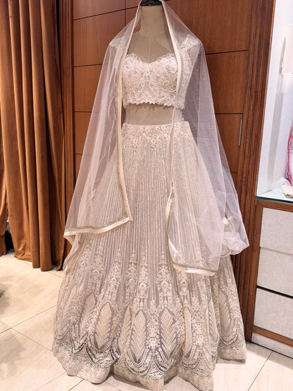 Lace wedding dress with a veil on a mannequin against a wooden panel background