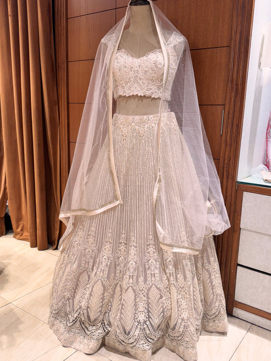 Lace wedding dress with a veil on a mannequin against a wooden panel background