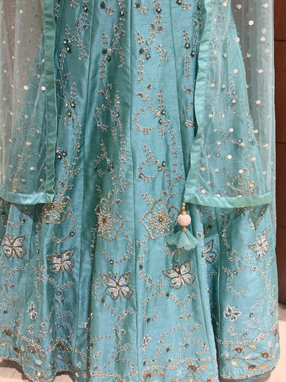 Light blue embroidered fabric with floral patterns and beads.