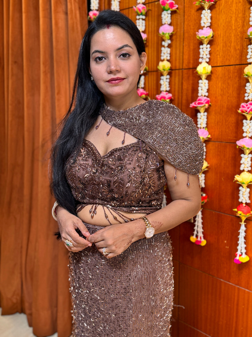 Woman in a sparkly outfit standing in front of a wooden wall with decorative elements.