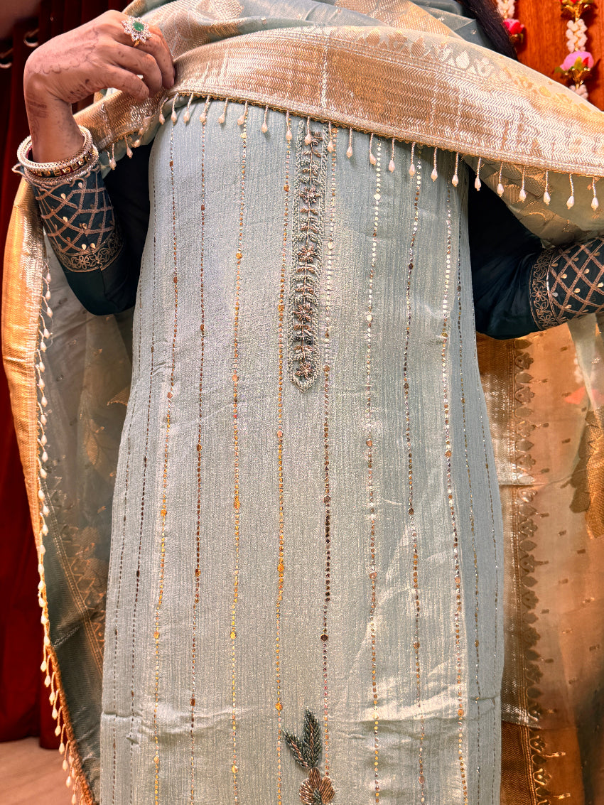 Close-up of a person holding a large piece of fabric with intricate patterns.