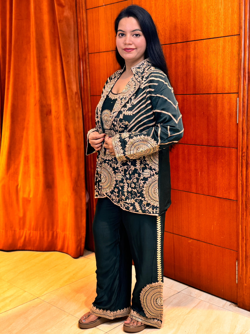 Woman wearing a traditional outfit with intricate patterns in front of an orange curtain.