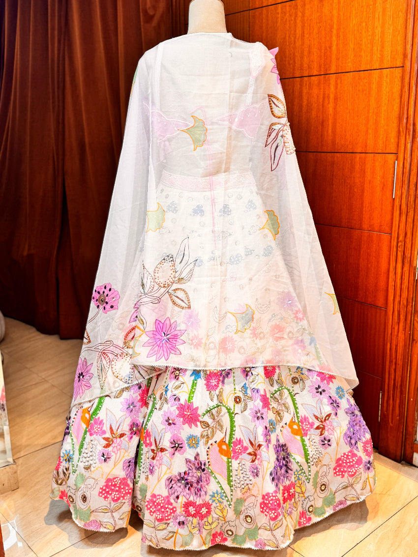 Floral embroidered dress on a mannequin against a wooden door background