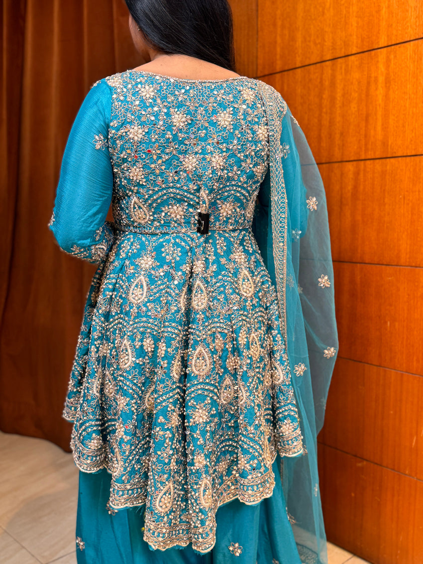Blue embroidered traditional outfit with a wooden background